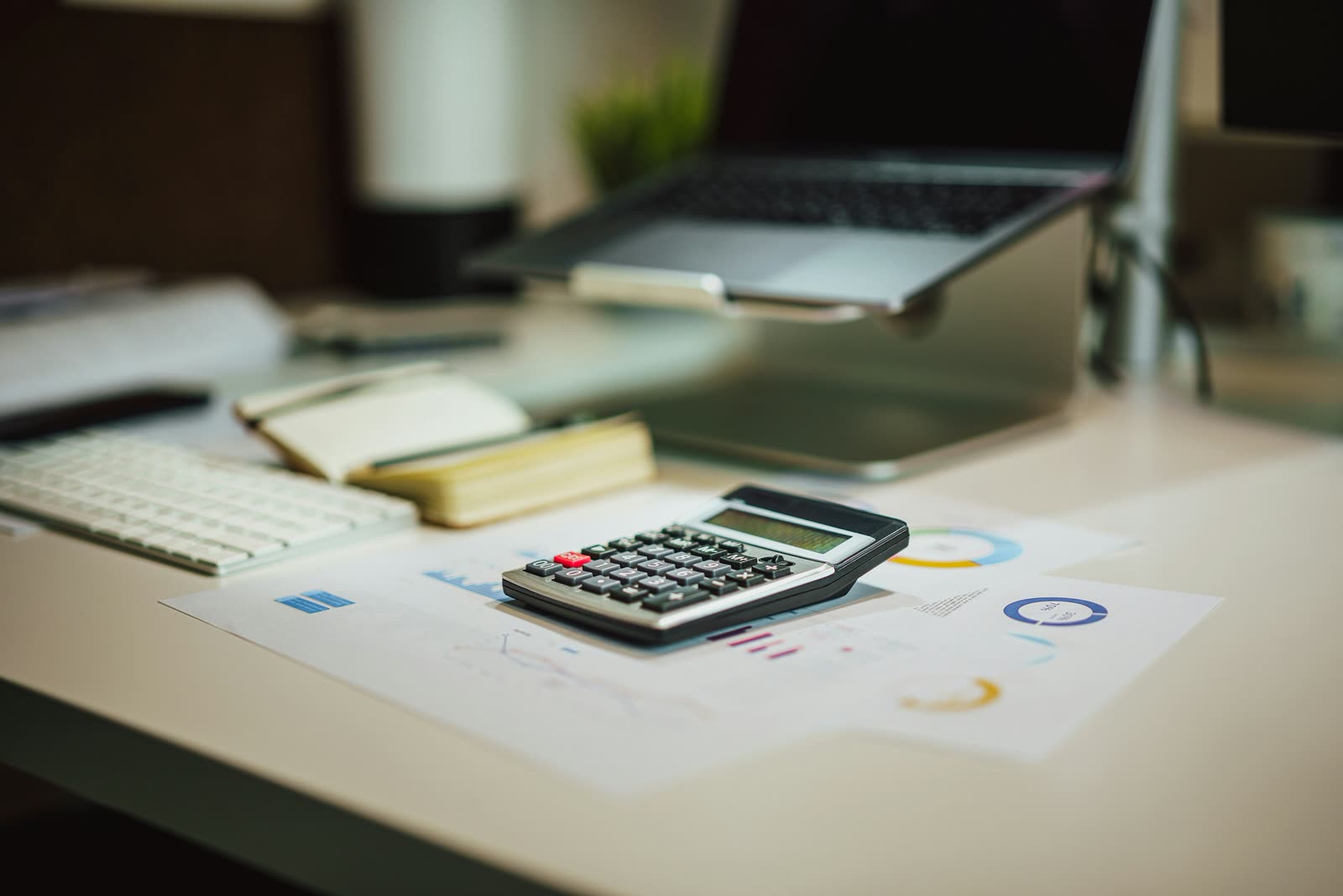 A calculator and charts on a bright desk