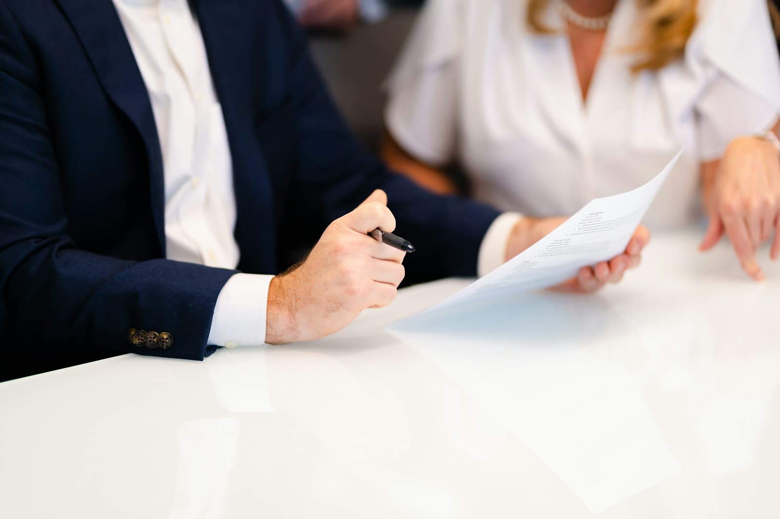 Two people reviewing papers at a bright desk